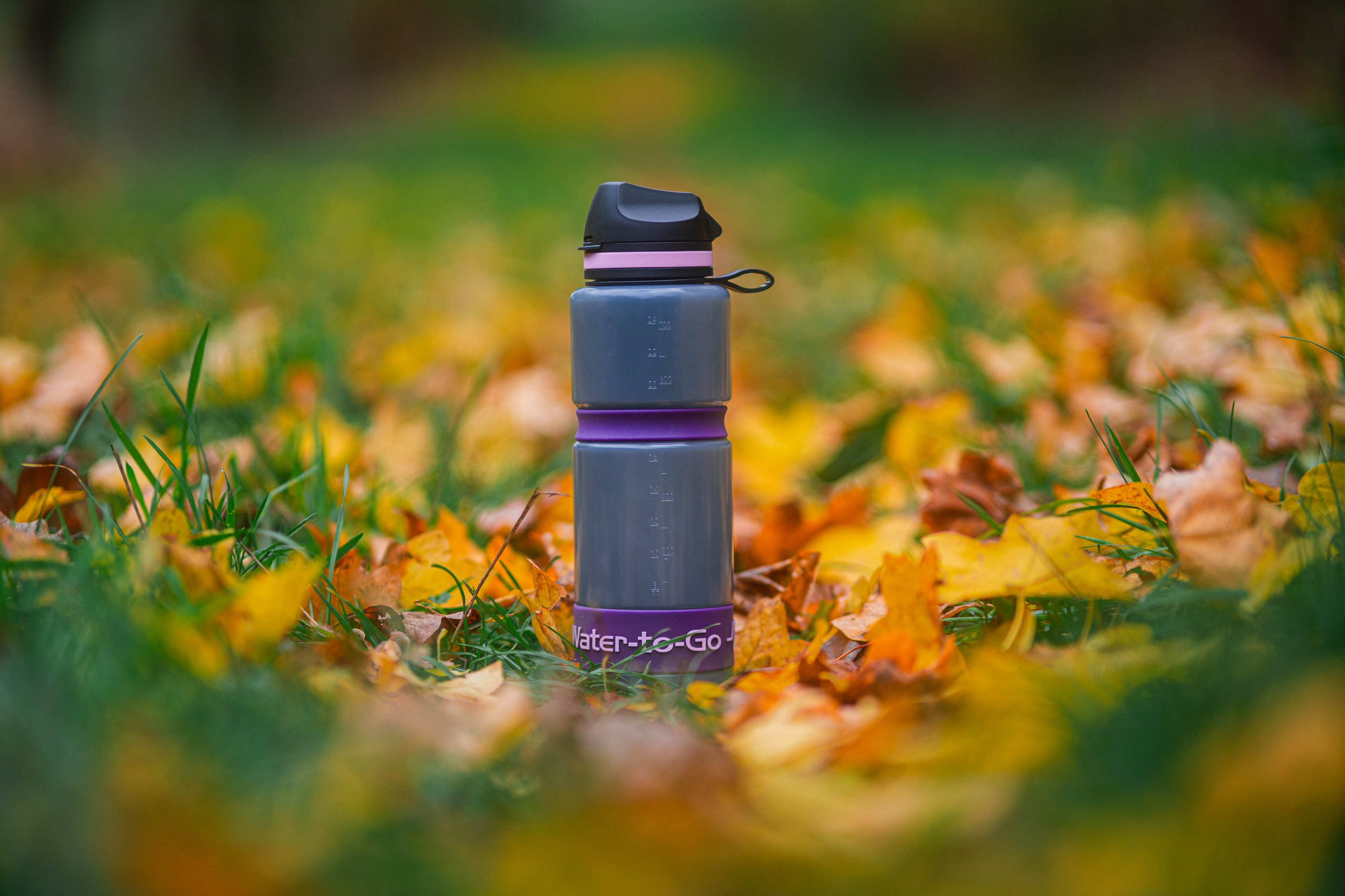 water to go filter bottle and band on grass and leaves