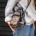 young lady wearing a water to go Insulated Bottle Carrier in camo colourway