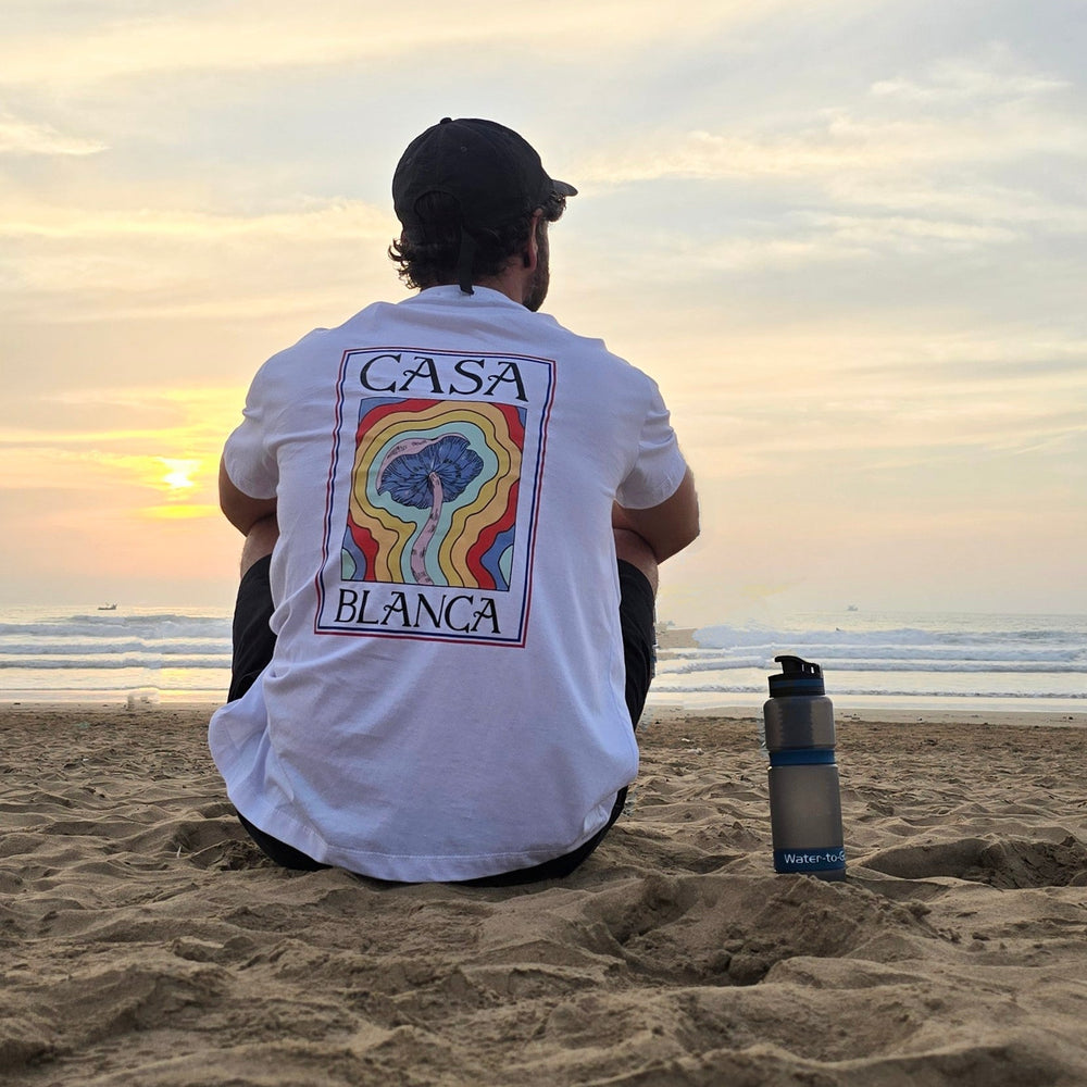 man sat on a beach next to water to go virus filtering bottle 
