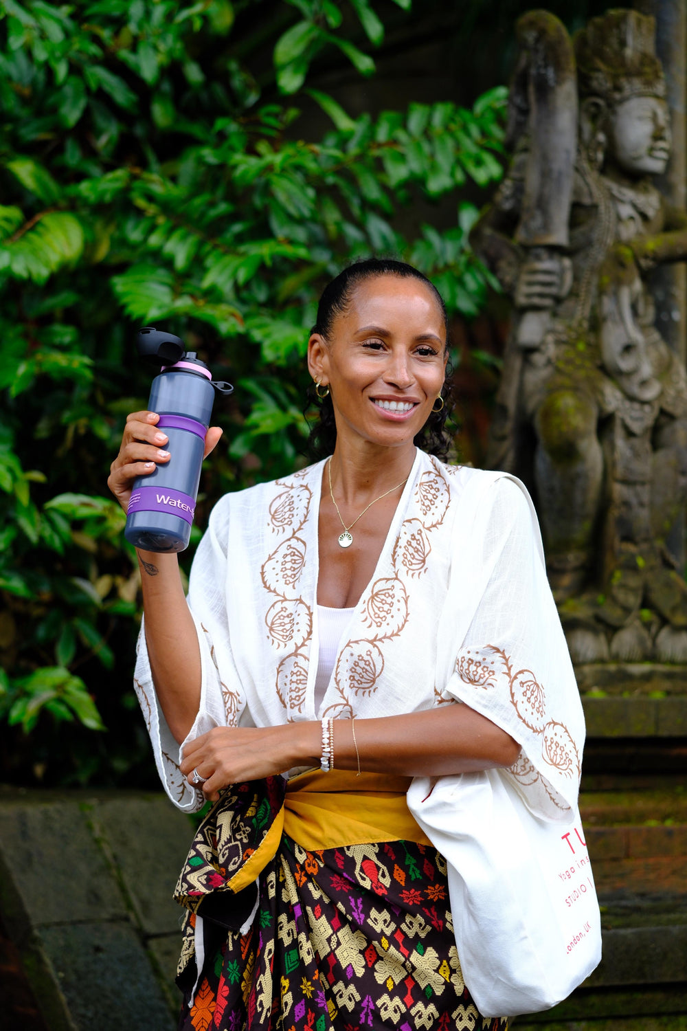 woman smiling holding acai colour filter water bottle with water to go branding